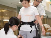 Physical therapists putting Honda's walking assit device on a trainee (image)