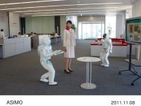 ASIMO interrupts its presentation to the customer to inform them of the arrival of drinks