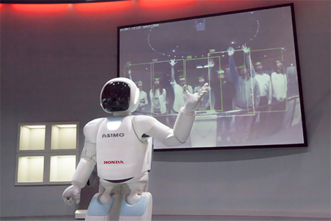 ASIMO showing a captured picture on the display and explaining its own features