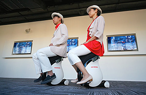 Japan Pavilion attendants riding UNI-CUB β