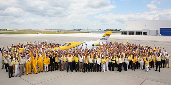 Honda Aircraft Company associates gather to celebrate the first flight of the fourth conforming HondaJet aircraft with the company’s president and CEO, Michimasa Fujino, at far left.
