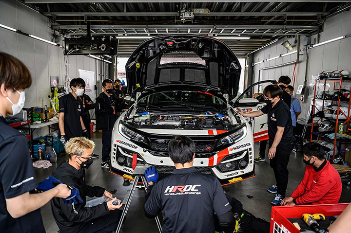 Young Honda R&D Challenge members serving as mechanics make final adjustments to the car.