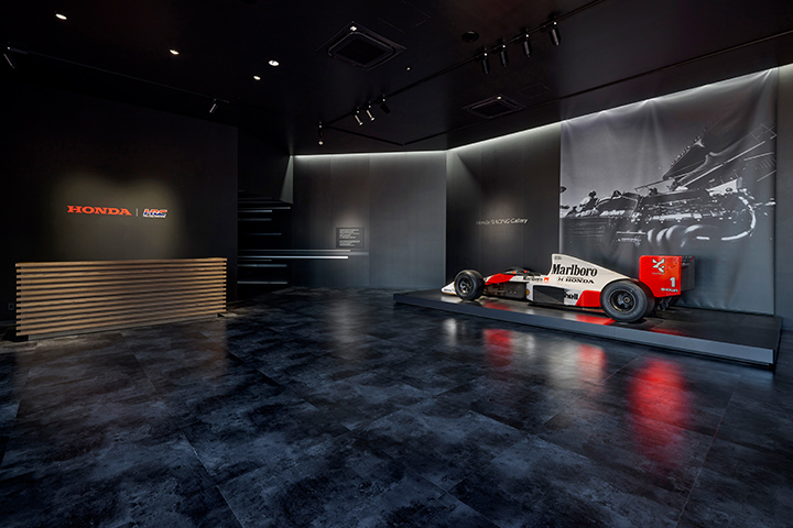 After entering the Gallery, visitors walk through the “speed tunnel” that generates an exciting anticipation, and emerge into a main hall, which is designed as a blackened space with spotlights helping the colors and shapes of the race machines stand out in contrast.