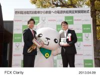 燃料電池電気自動車から家庭へ電力を供給する実証実験のオープニングセレモニー 「FCXクラリティ」の「ゴールドキー」と、北九州市の環境マスコットキャラクター「ていたん」のぬいぐるみの贈呈式　左から、北九州市 市長　北橋 健治、本田技研工業（株）専務取締役　山本 芳春