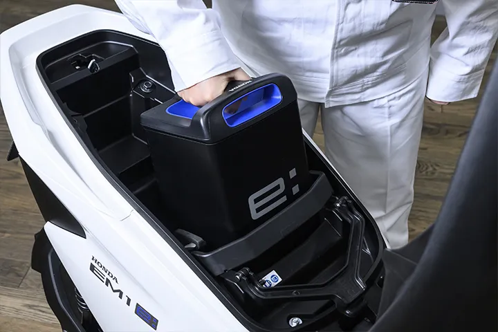 シート下のスペースに交換式バッテリーを搭載。「Honda Mobile Power Pack e:」の重さは10kg程度。 「持ち運びしやすいT字ハンドルがポイントです」（後藤）