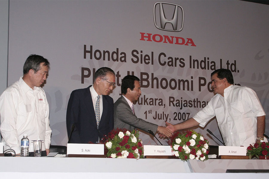 式典で握手を交す甘利経済産業大臣とNarpat Singh Rajviラジャスタン州産業大臣。 左から：青木哲Honda会長。林JETRO理事長。