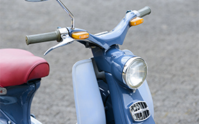 Handlebars & Front Visage In every aspect, the Super Cub featured an aesthetically pleasing design, including its wing-like handlebars and brake lever. Produced at Honda’s Saitama plant, its light bluish gray plastic parts were also a distinctive feature of this early model.