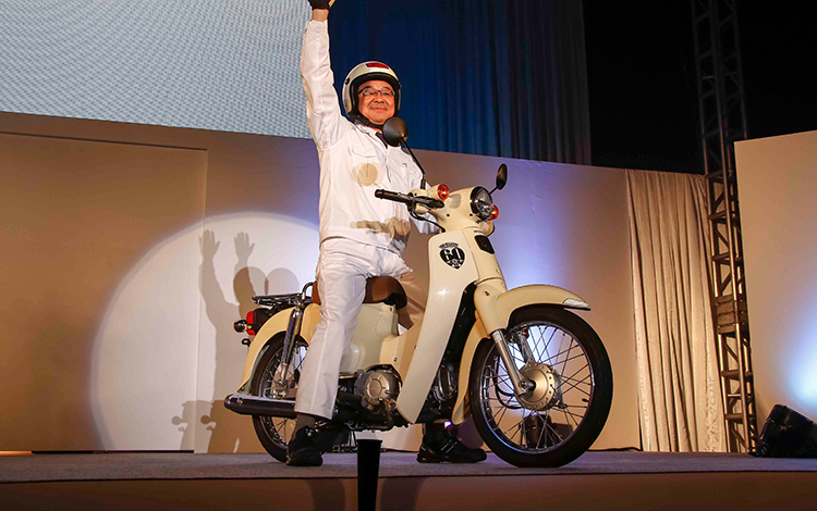 Honda CEO Hachigo appearing on a Super Cub.
