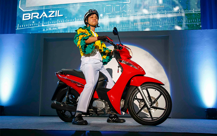 Honda associates dressed in ethnic costumes appeared on Super Cubs from various countries. (Brazil)