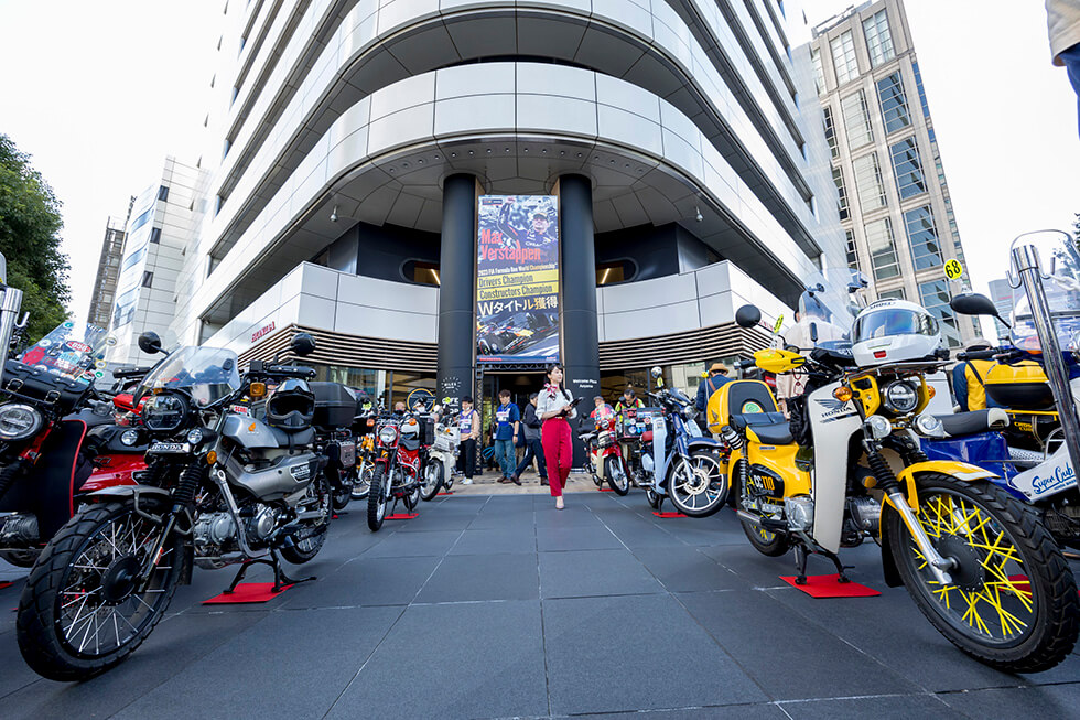 Participants' Super Cubs neatly lined up outside of Honda Welcome Plaza Aoyama, as passersby looked on with great interest. Over the years, the event has become a Autumn tradition in Aoyama.