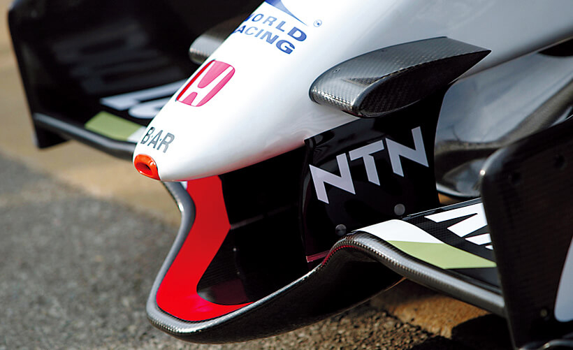 Front wing asserts individuality. The bottom of the 50 cm-wide center section doubled up with the floor center section (not included in the wing height limitation, allowing ground effects use). This also efficiently channeled airflow to the underside of the cockpit.