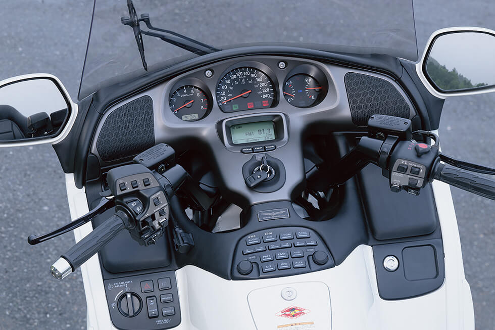 Various switches neatly laid out in the cockpit. The LCD display located below the speedometer shows various information such as travel distance, temperature, and audio mode.