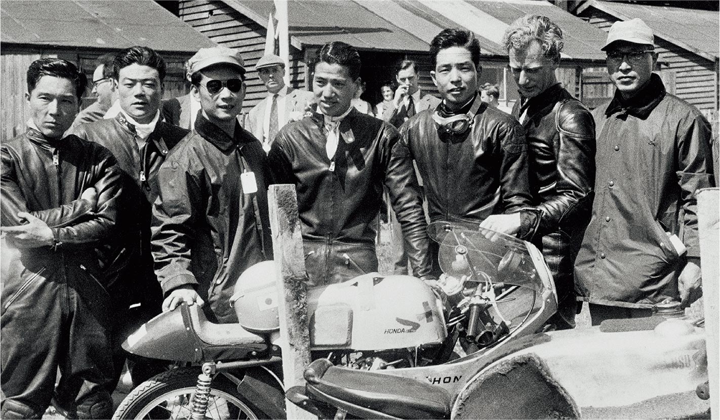 First appearance in the Isle of Man TT Races (1959) From left: Junzo Suzuki, Giichi Suzuki, Kiyoshi Kawashima, Naomi Taniguchi, Teisuke Tanaka, Bill Hunt, and Hisaichi Sekiguchi (chief of maintenance)