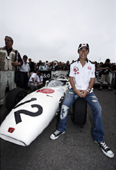 Takuma Sato sits on the front tire of the RA272, the same model that gave Honda its first F1 victory 40 years ago driven by Richie Ginther. Hopes are high for Sato’s future F1 career.