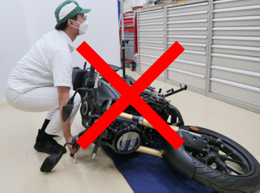 Extend the side stand and hold the front brake (if the bike has fallen to the right)
