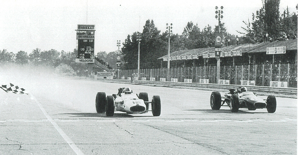 1957年9月のイタリアGP でチェッカーフラッグを受ける ジョン・サーティ{左)。車体は口ーラ社との共同開発で軽量化が図られ、2度目の勝利を挙げた