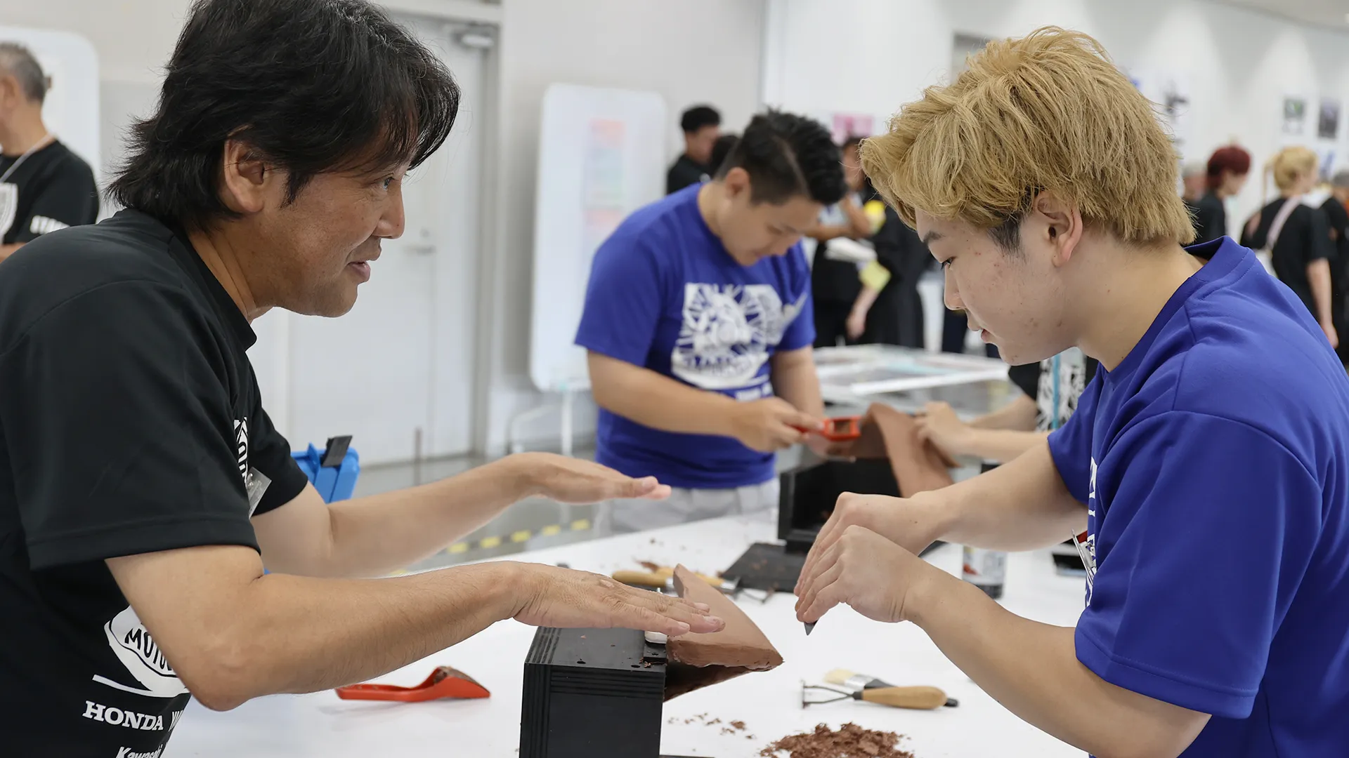 クレイモデリング講座で学生に道具の使い方を教える講師