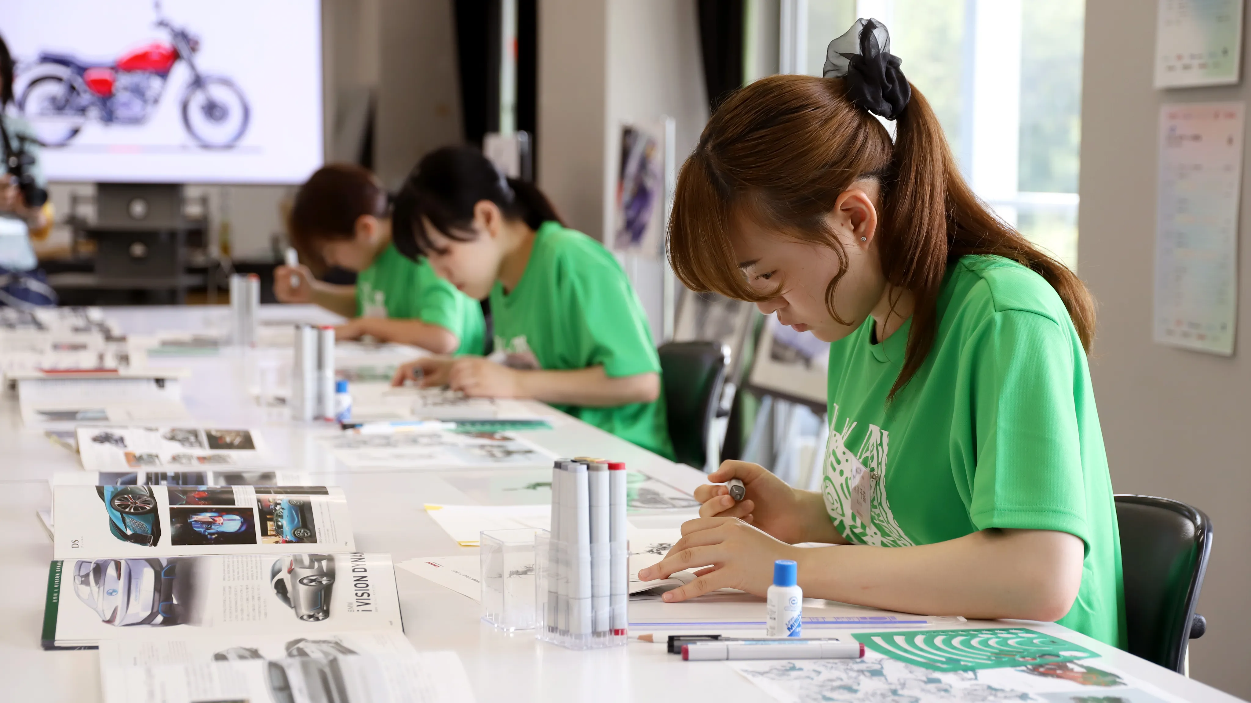 資料を参考にスケッチに取り組む学生たち