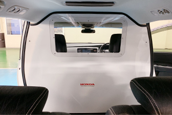 運転席と後部座席に仕切りを設けた感染者搬送車両