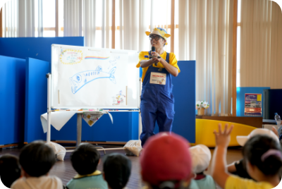 大分県での環境授業。絵を描いて特徴を説明しながら、「このお魚さんは何でしょう？」と子どもたちに出題するさかなクン