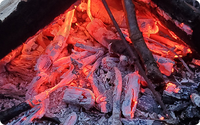 赤々とした火床ができれば、太い薪にも火が燃え移る。