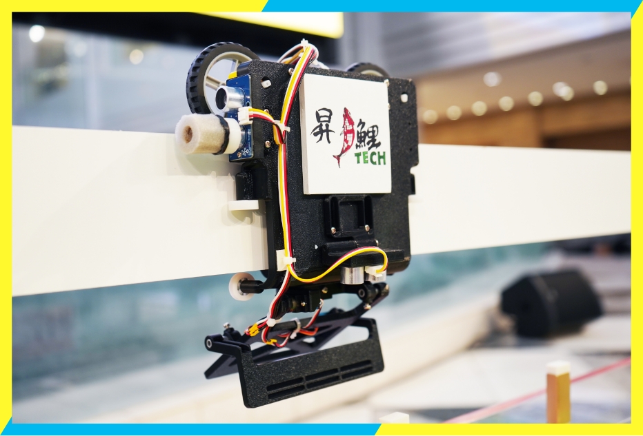 高い位置の競技フィールドに設置された高得点が入る金の消しゴムを認識し、下に叩き落とすロボットは、チームメンバーで協力してプログラミングしたロボット